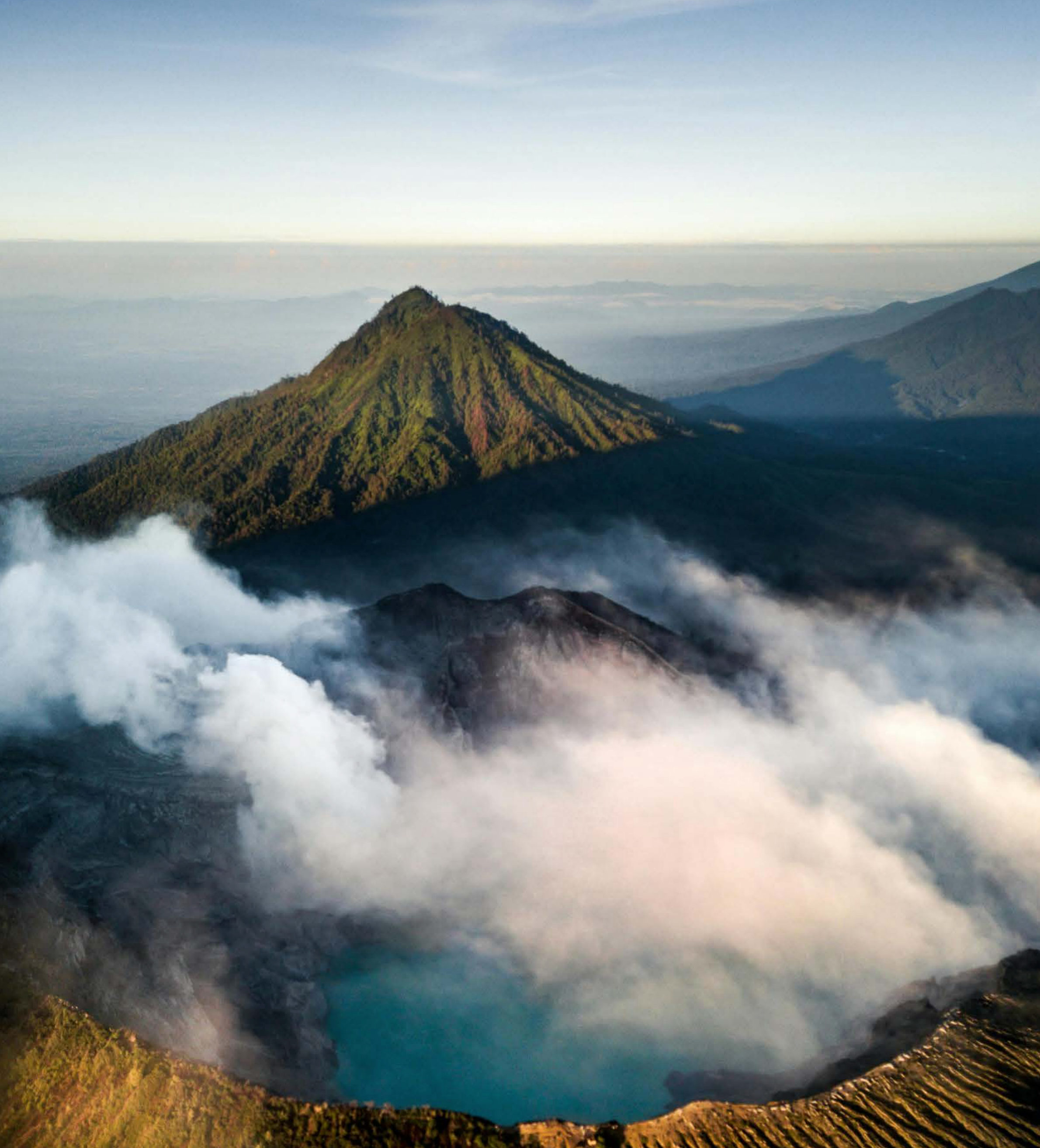 Volcanic crater lake and steam at sunrise